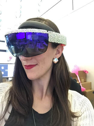 Picture of a woman with long brown hair wearing a diamonte encrusted virtual reality headset